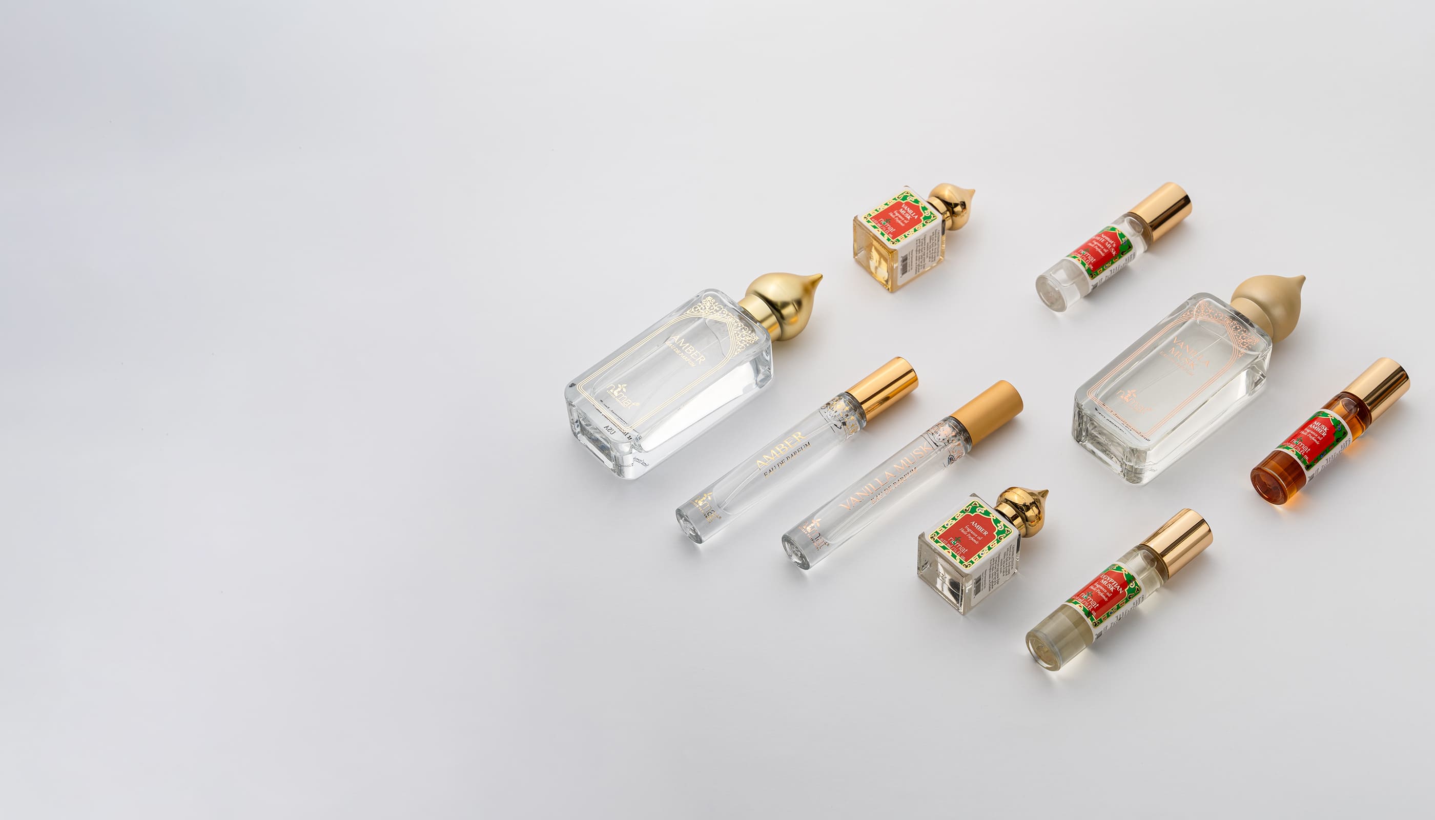 Collection of small perfume bottles with colorful labels on a light gray background