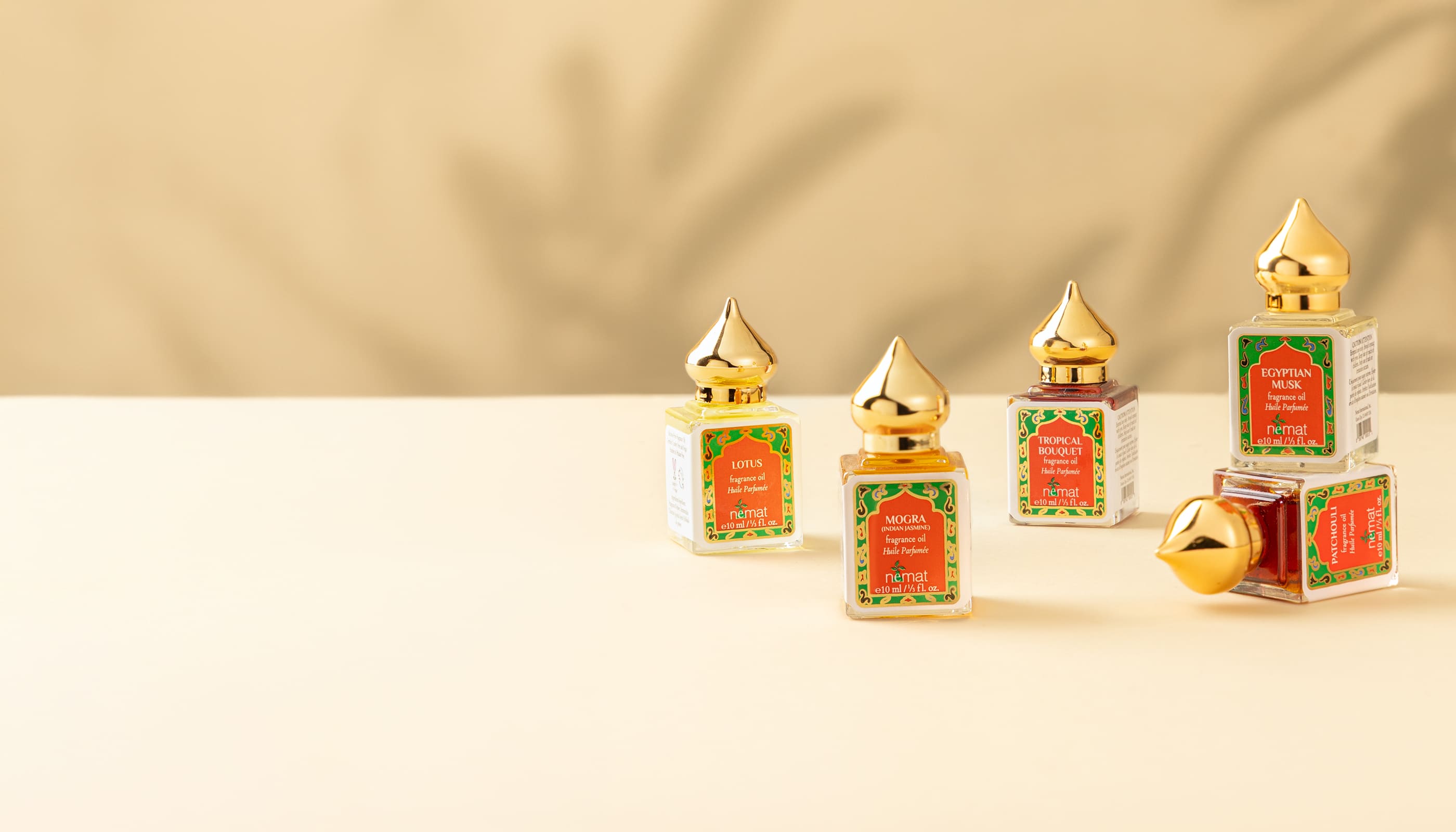 Set of perfume oil bottles with gold caps on a beige background